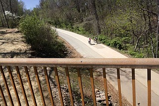 People are ride bikes Thursday from the pedestrian bridge at the one-mile mark for the All-American Mountain Bike Trail in Bentonville. Visit nwaonline.com/photos for today's photo gallery.

(NWA Democrat-Gazette/Charlie Kaijo)